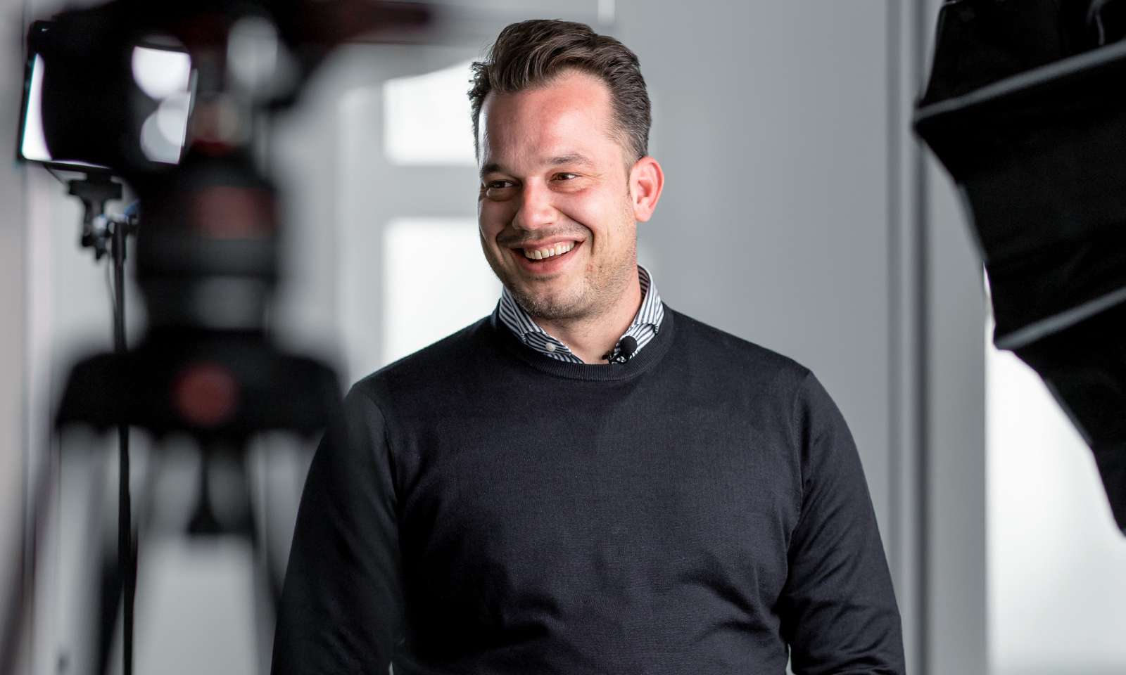 Nicolas Mertzios steht in einem Fotostudio und lächelt