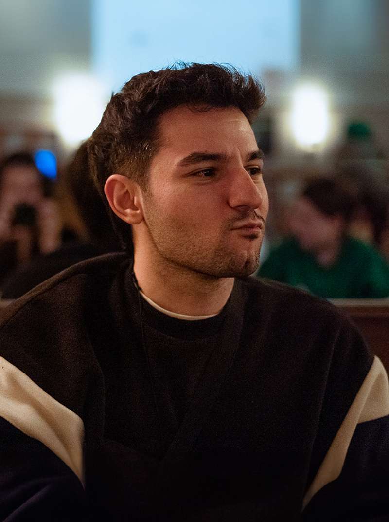 Ugur sitzt in einem Restaurant und schürzt die Lippen.
