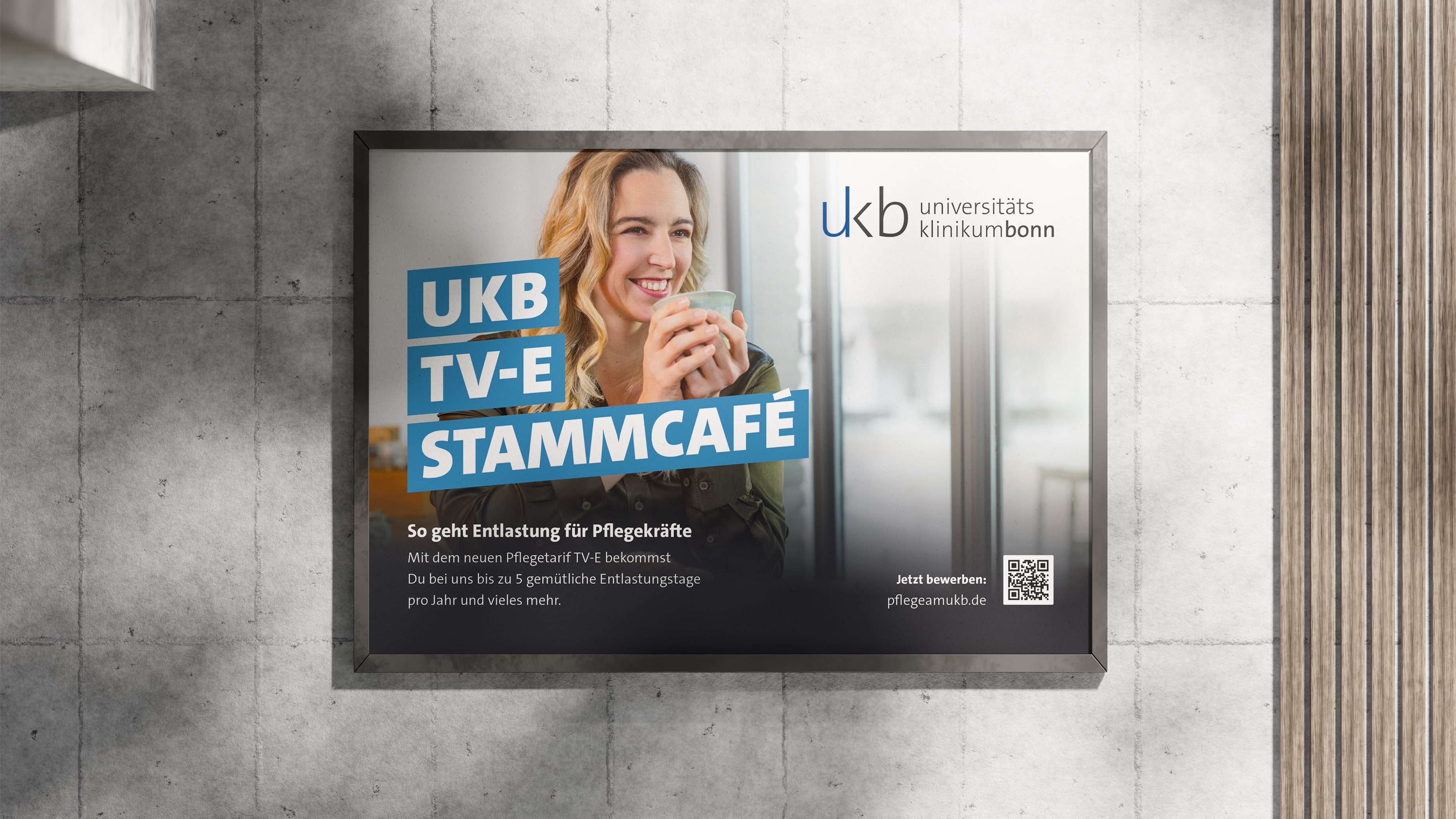 Mockup eines Kampagnenplakats an einer Betonwand; Pflegekraft trinkt Kaffee; Zu lesen ist der Claim „UKB, TV-E, Stammcafé“